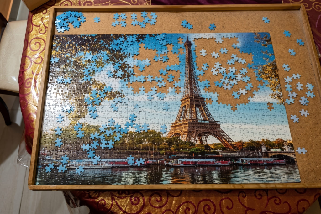 Working on a jigsaw puzzle as a relaxing hobby, perfectly capturing intentional living and hygge at home.